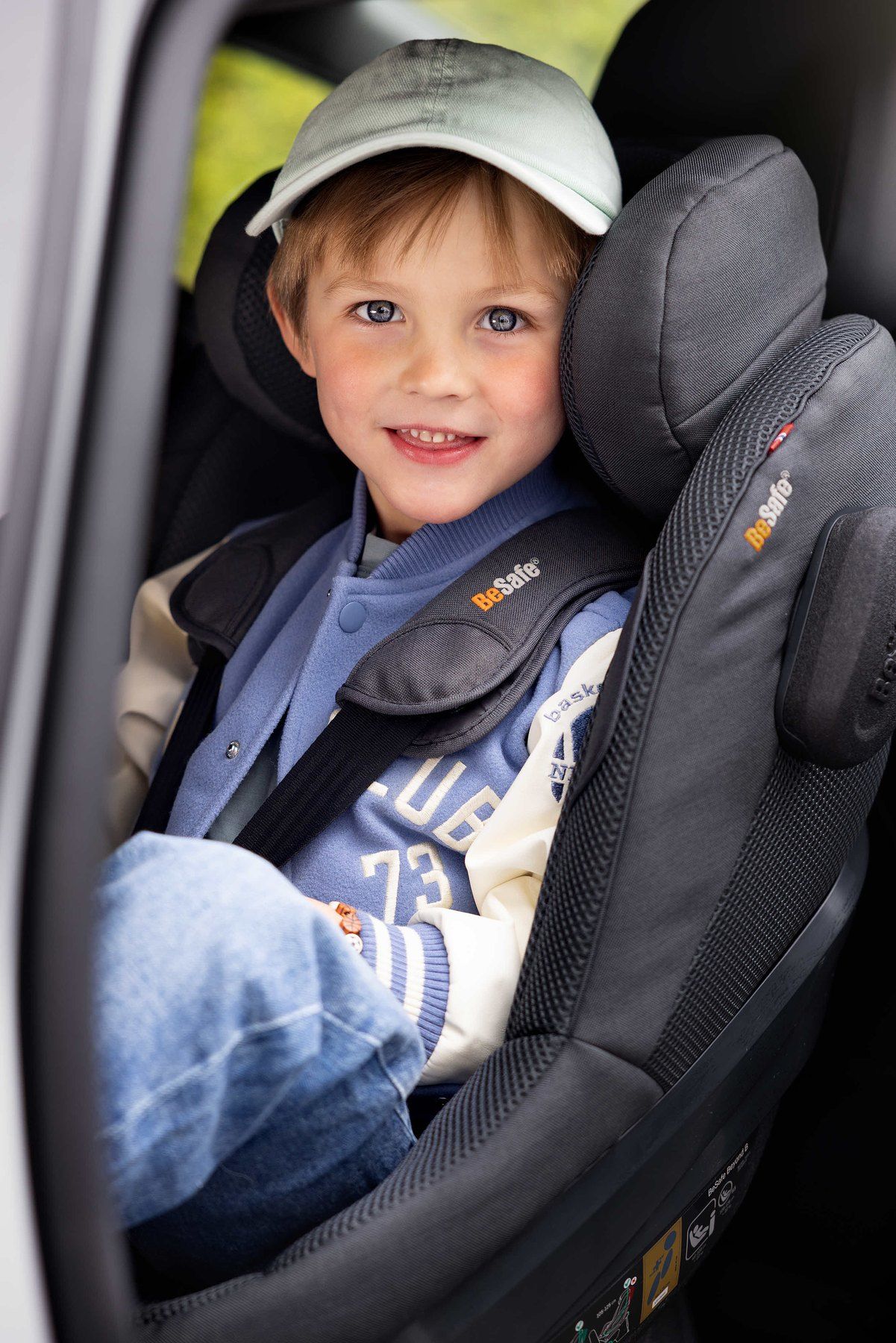 Un petit garçon souriant dans un BeSafe Beyond installé en voiture.