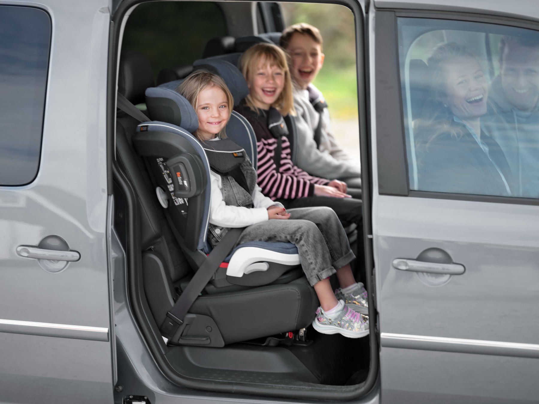 Trois enfants assis à l'arrière d'un monospace, dont un sur un BeSafe iZi Flex Fix.