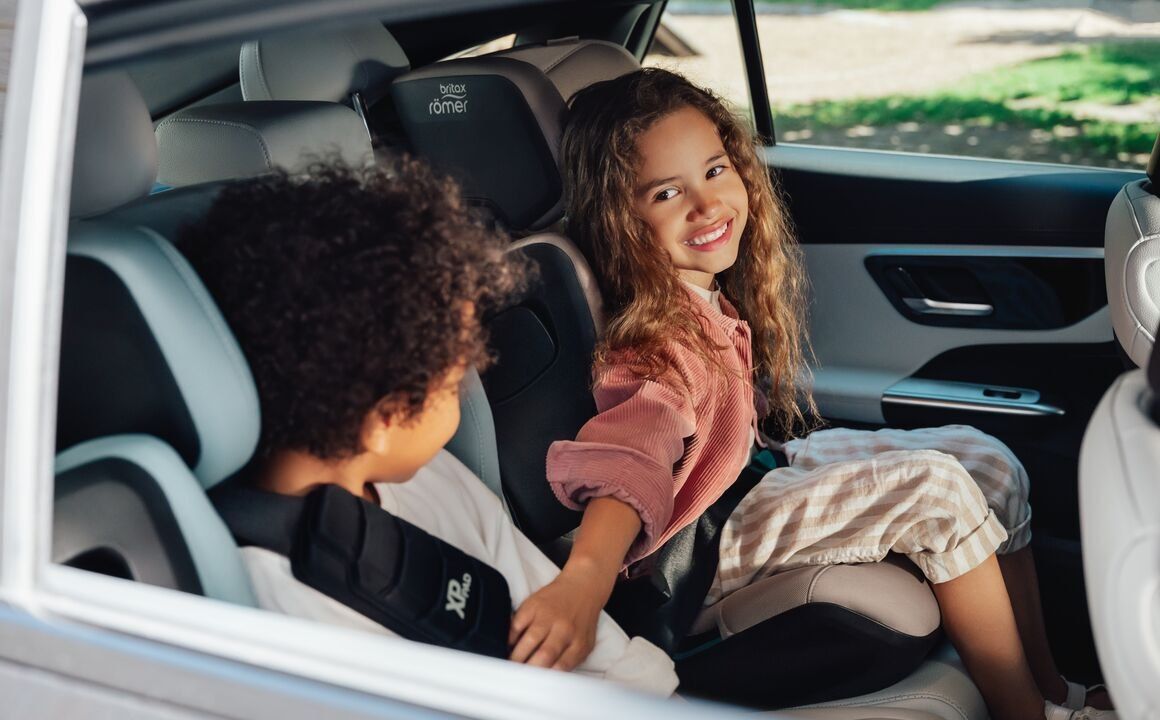 Deux enfants à l'arrière d'une voiture, la fillette est assise dans le Kidfix Pro et regarde son frère
