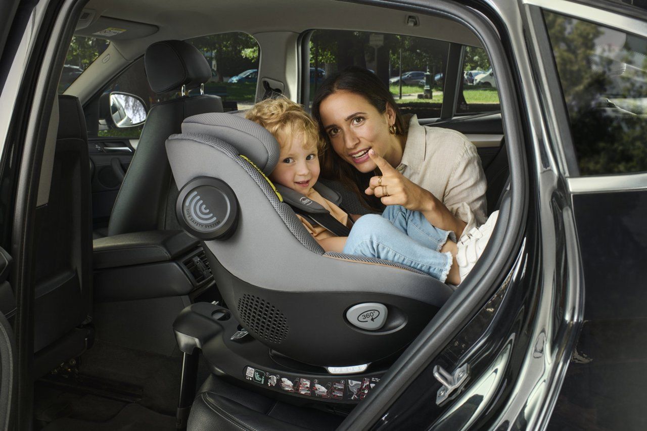 Une maman et son enfant qui sourit dans le siège Chicco Seat105 installé sur la banquette d'une voiture.