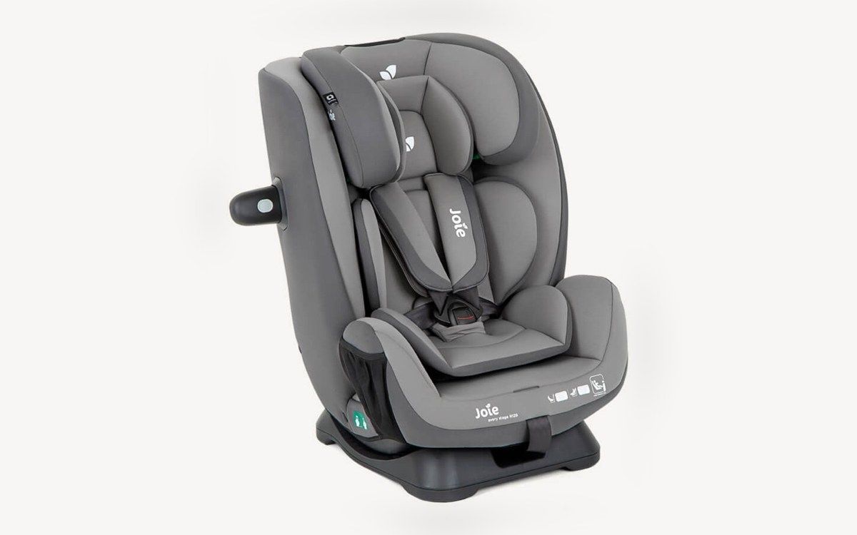 Siège auto Joie Every Stage R129 vu de trois quarts, avec harnais et réducteur