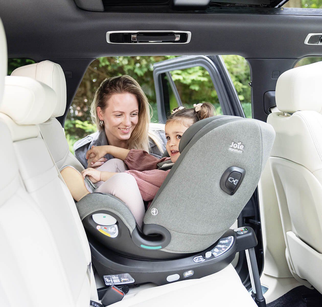 Une maman et son enfant à l'arrière d'une voiture, dans un siège Joie i-Spin XL tourné vers la portière