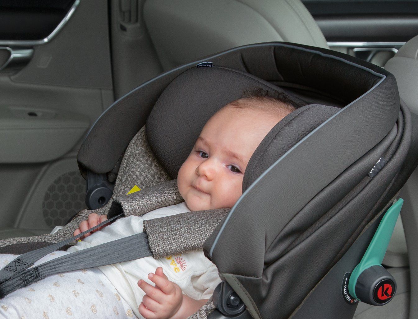 Bébé attaché dans la coque Peg Perego Primo Viaggio installée dos à la route à l'arrière d'une voiture