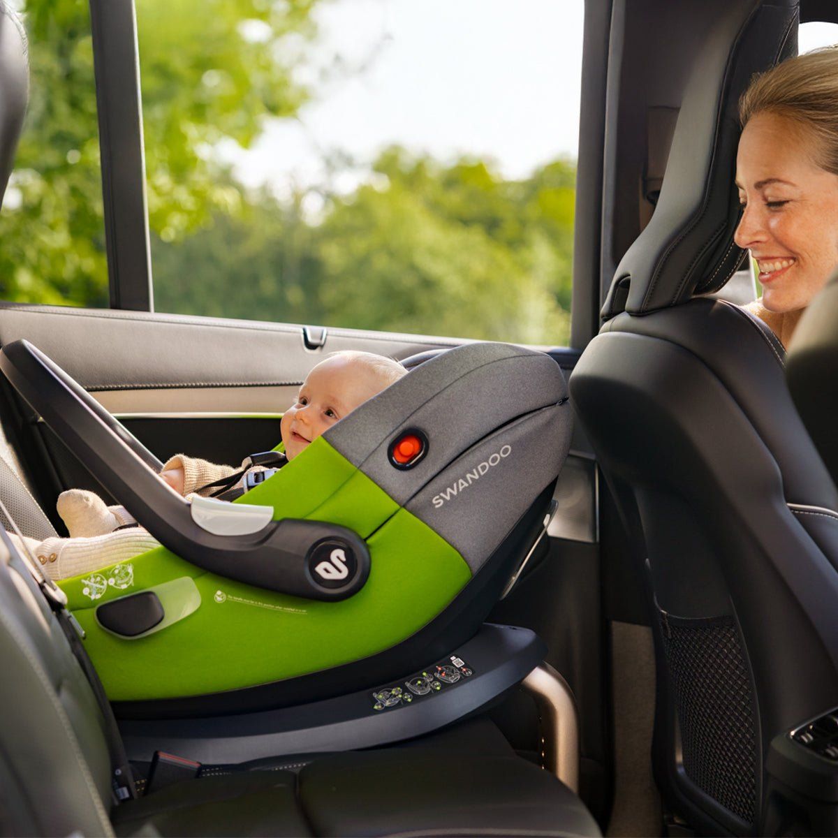 Une maman sourit à son bébé installé dans la coque Swandoo Albert, à l'arrière d'une voiture.