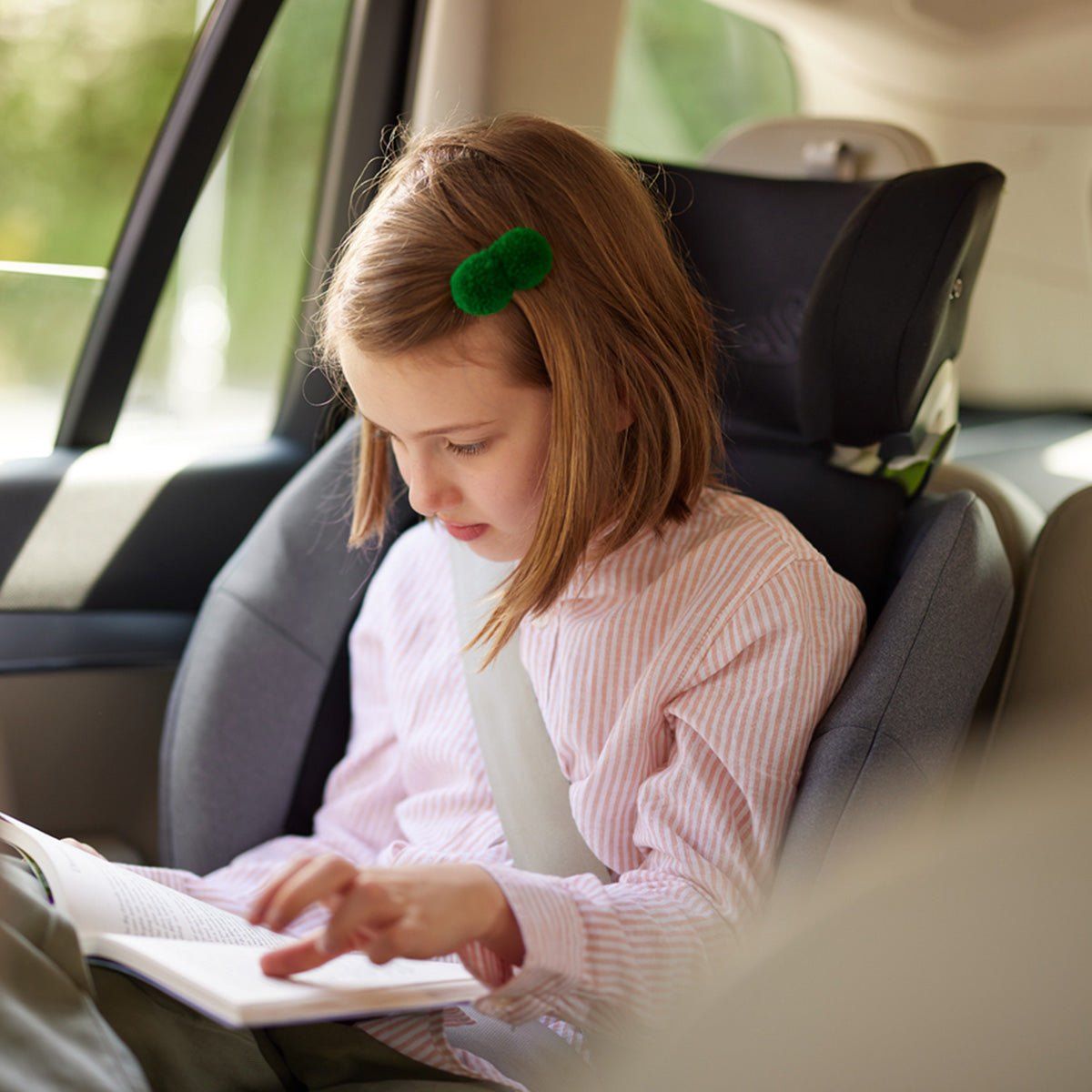 Une fillette concentrée sur son livre, assise sur un Swandoo Charlie.
